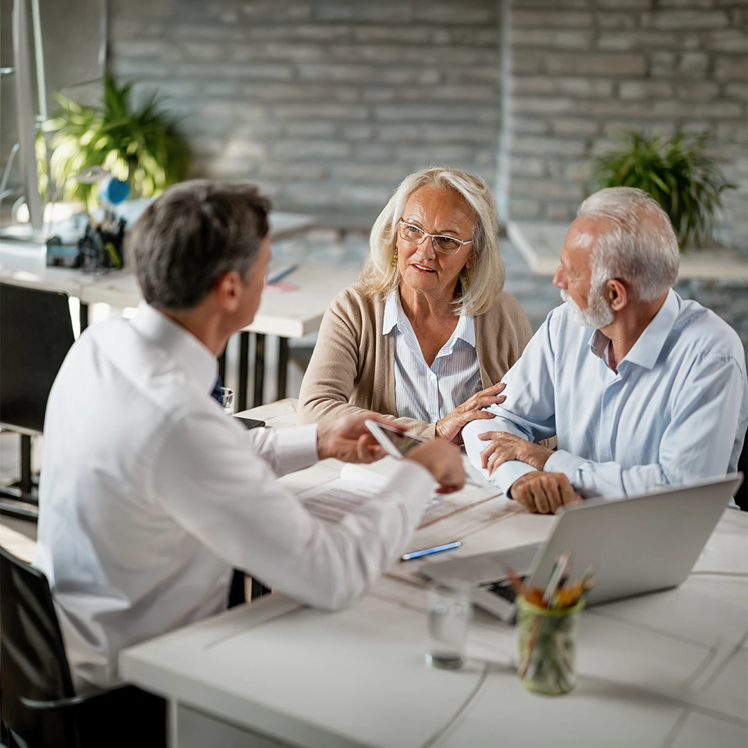 Senior and insurance agent discussing Medicare coverage options in a friendly meeting